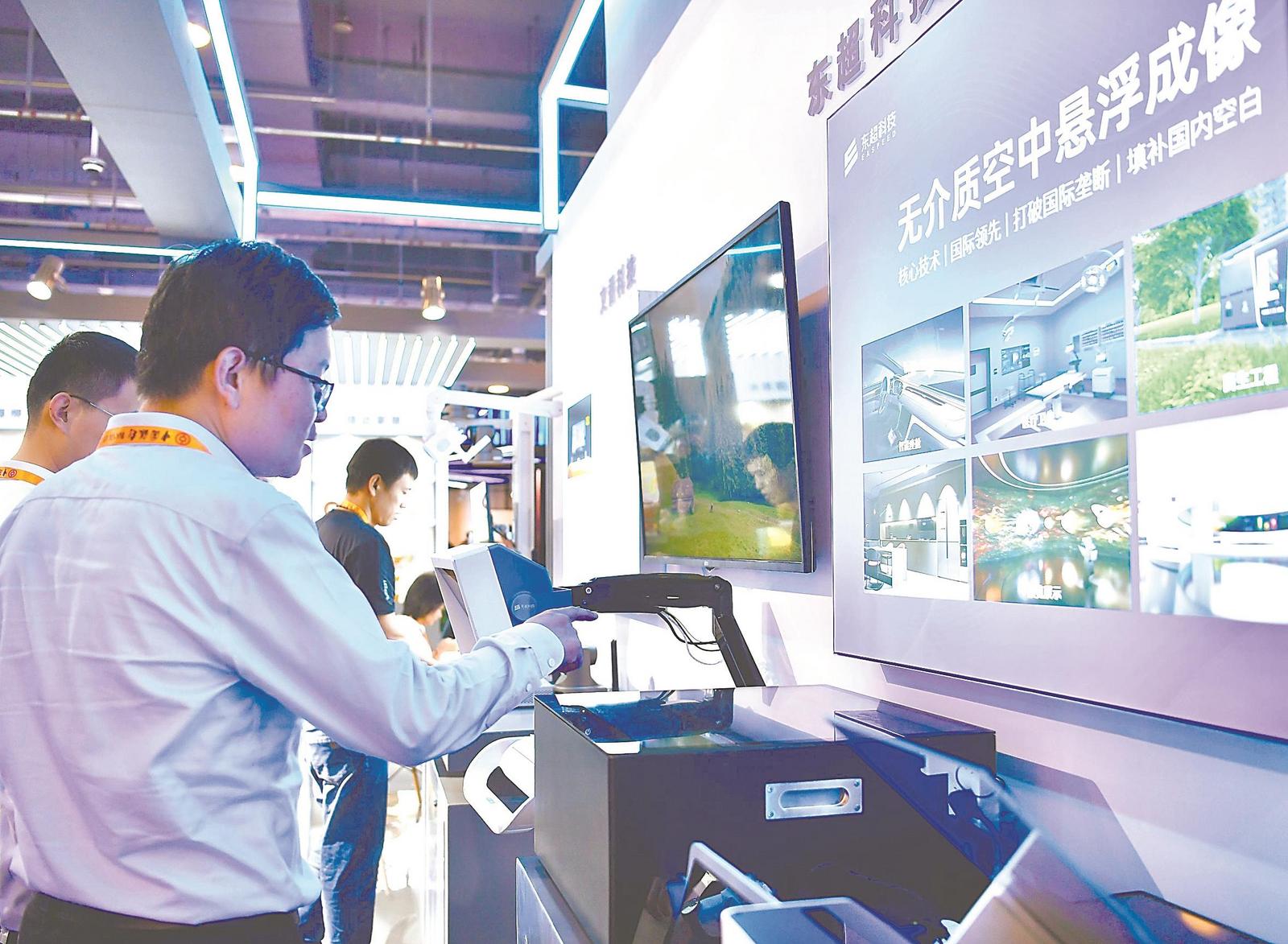 安徽馆内,参观者体验东超科技“无介质空中悬浮成像”设备。