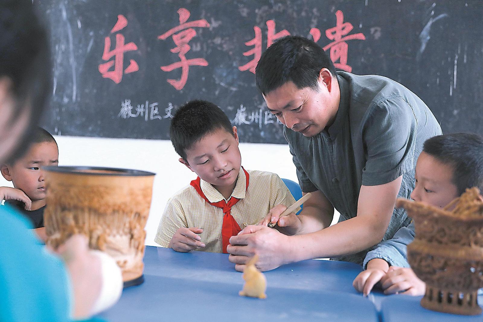 徽州竹雕非遗传承人洪建华向学生传授竹雕技艺。曹晓东 摄